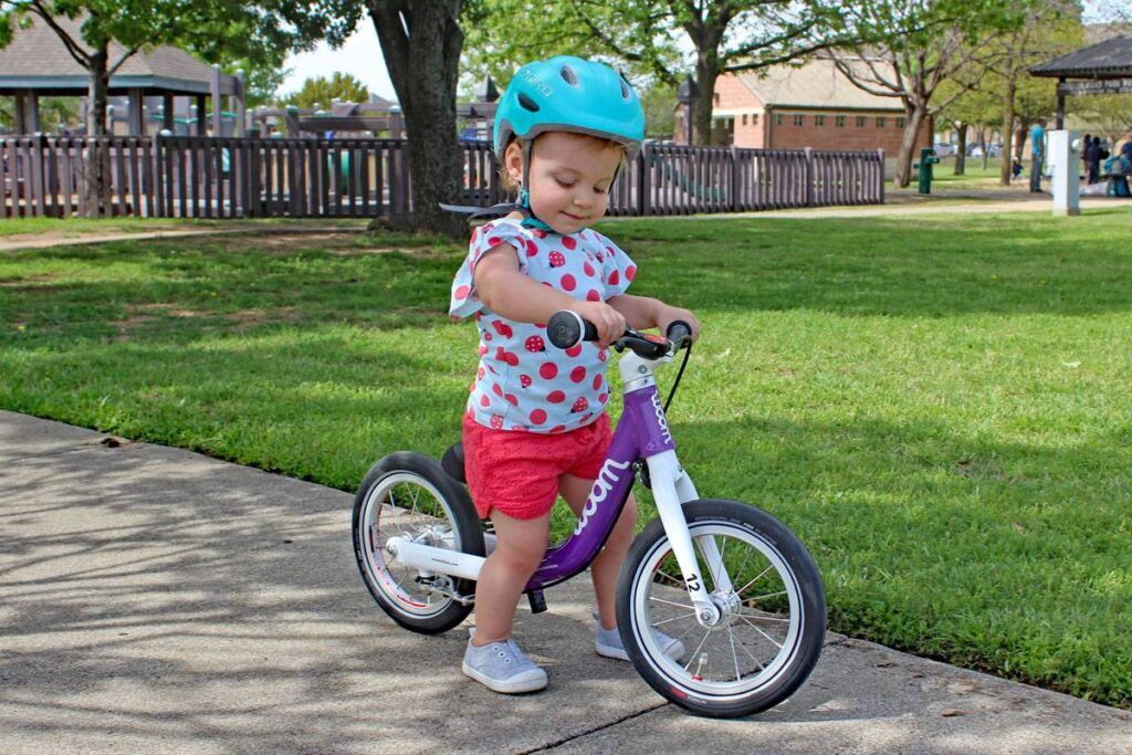 Young child walking tentatively on a balance bike