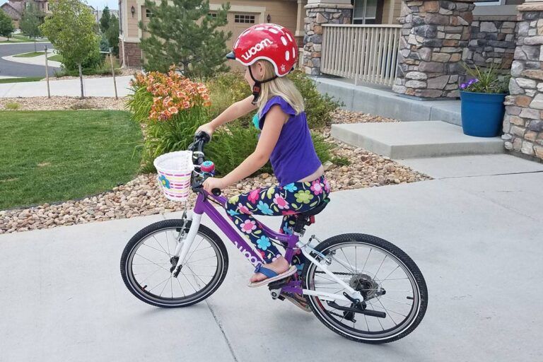 7 year old girl riding woom 4 in her driveway