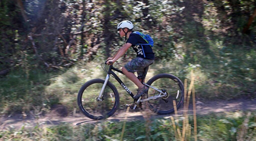 young boy riding the woom OFF 6 26 inch mountain bike