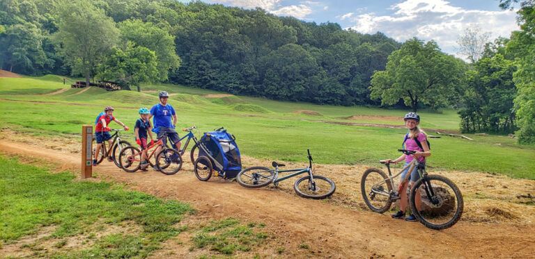 Family standing with bikes with North Skills Park at Slaughter Pen in Bentonville