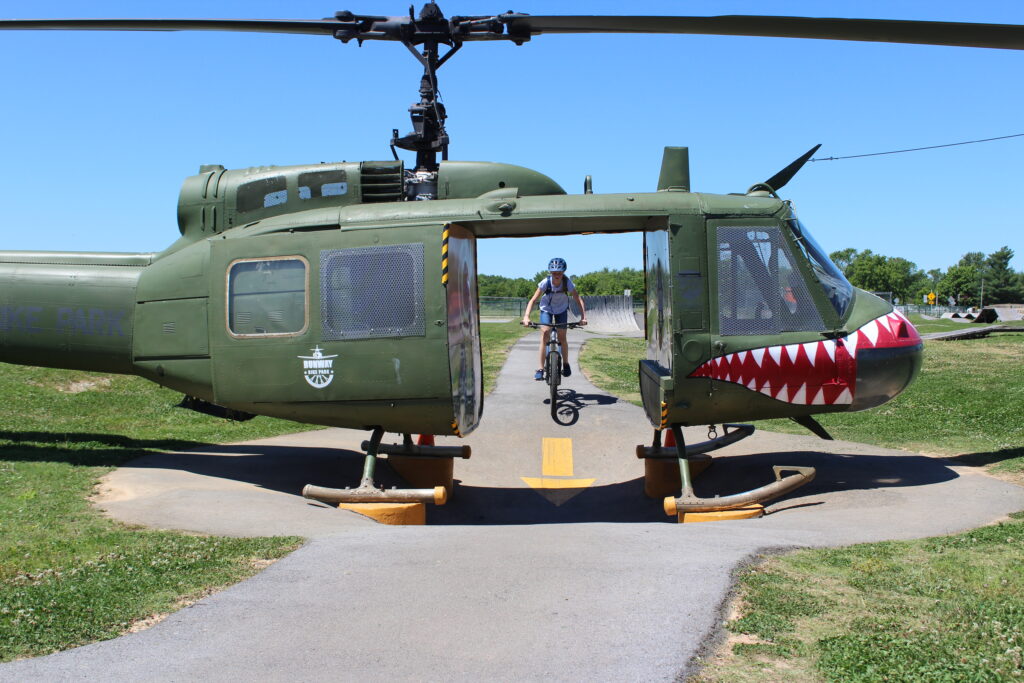 11 year old girl riding Marin Wildcat Trail 3 XS hardtail mountain bike through shark helicopter feature at Runway Bike Park
