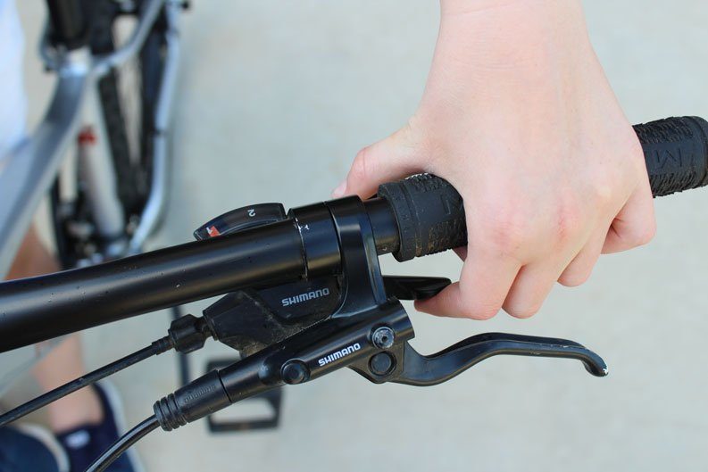 Girl with hand on trigger shifters of Marin Wildcat Trail 3 mountain bike