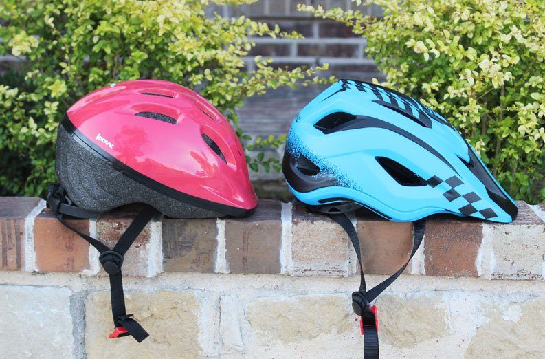 Side by side comparison of Joovy Noodle helmet and Strider ST helmet. Shows in-mold construction vs cheaper hardshell of Joovy.