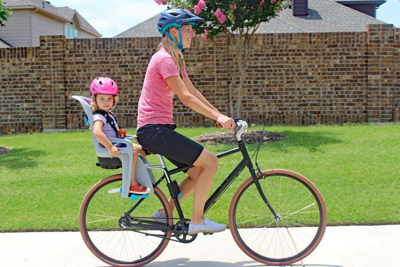 Mom riding Priority bicycle with toddler on the back in Thule RideAlong child bike seat.