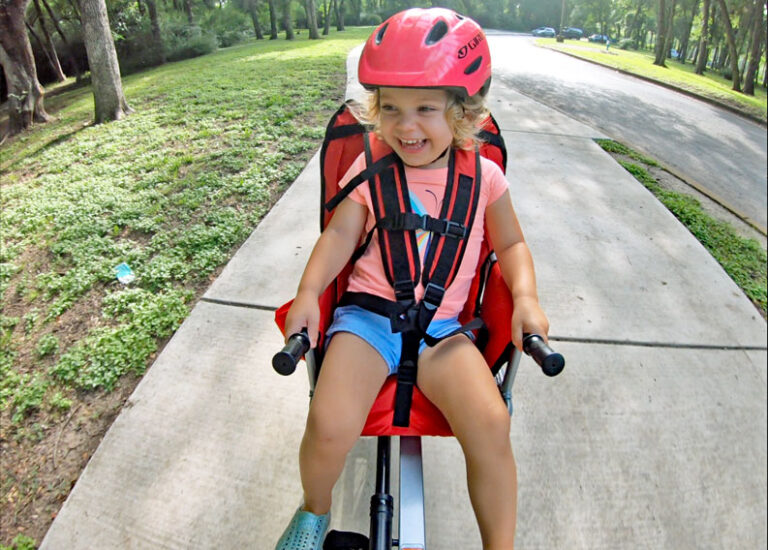 Toddler grinning while riding in the Weehoo Turbo