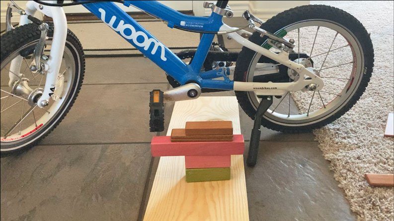 DIY bike trainer for teaching a child to learn to pedal. Made out of kids blocks.