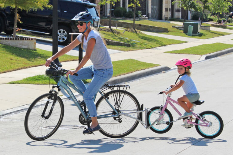Mom riding with 2.5 year old on her bike using the FollowMe Tandem bike coupling device