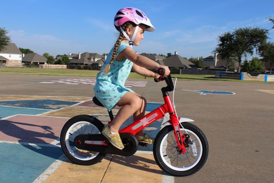 4 year old riding SmarTrike Xtend convertible balance bike in pedal bike mode