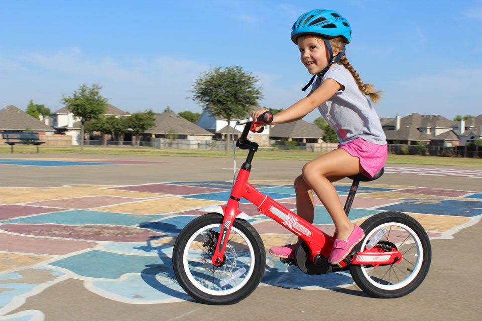 5 year old riding SmarTrike Xtend convertible balance bike in pedal bike mode