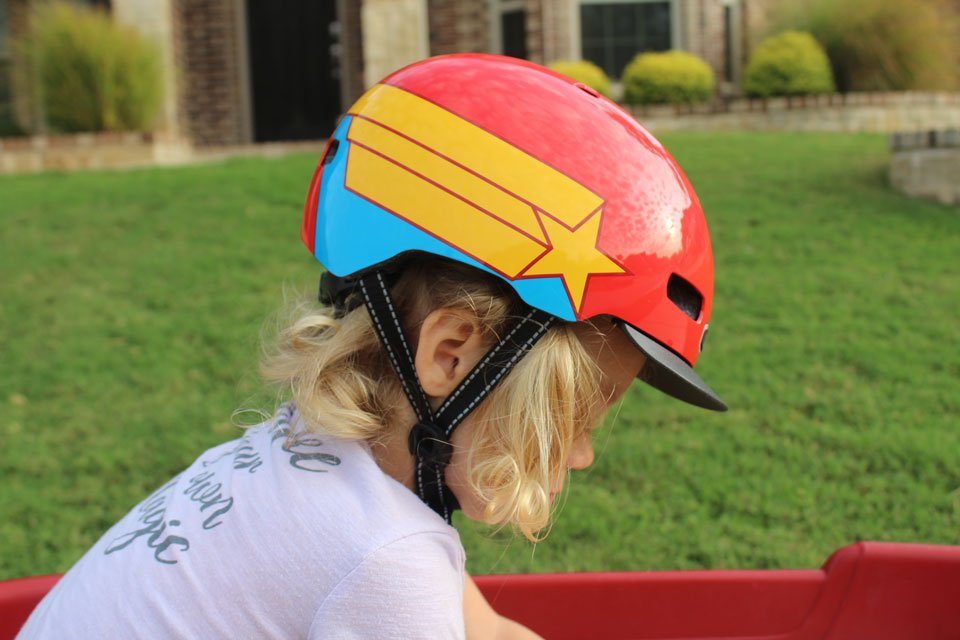 Side shot of toddler wearing the Nutcase Little Nutty. Showing straps forming a V under the ear.