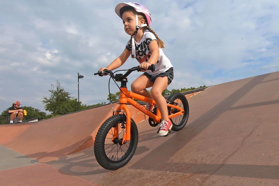 4 year old riding Park Cycles 14 inch bike down ramp at skate park