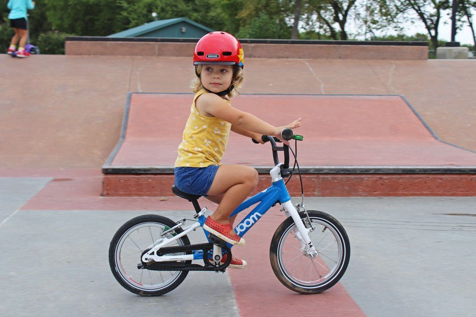 2 year old riding woom 2 balance bike at the skate park and wearing Nutcase Little Nutty helmet