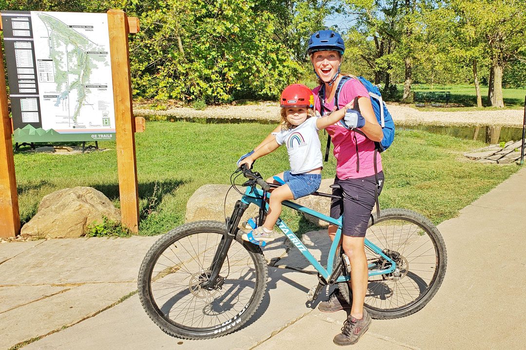 Mom on mountain bike with her toddler sitting on the MacRide child bike seat