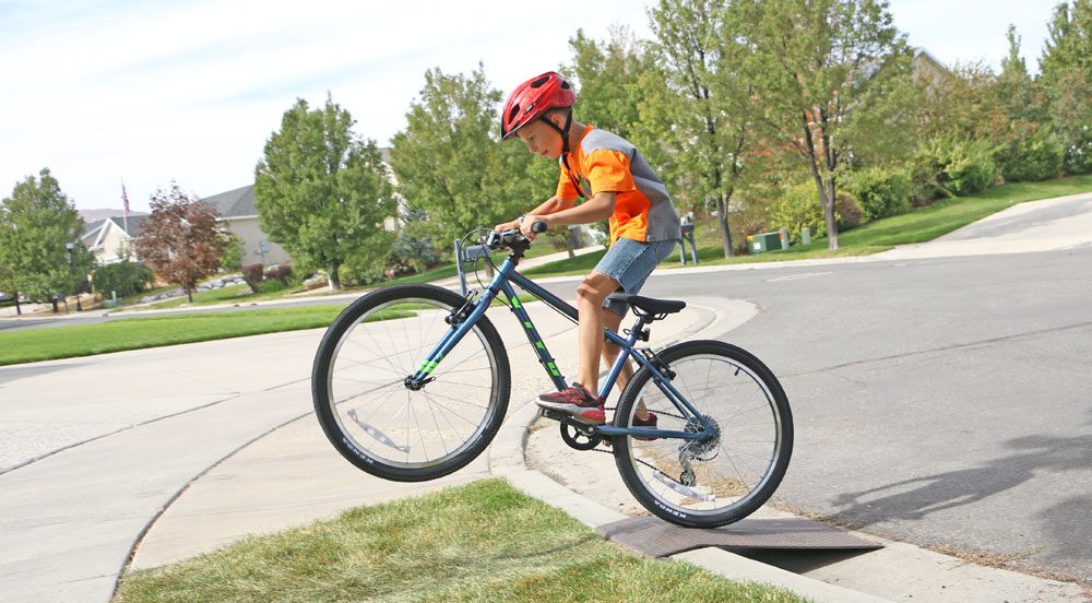 9 year old riding Vitus Kids 24 inch bike up a ramp