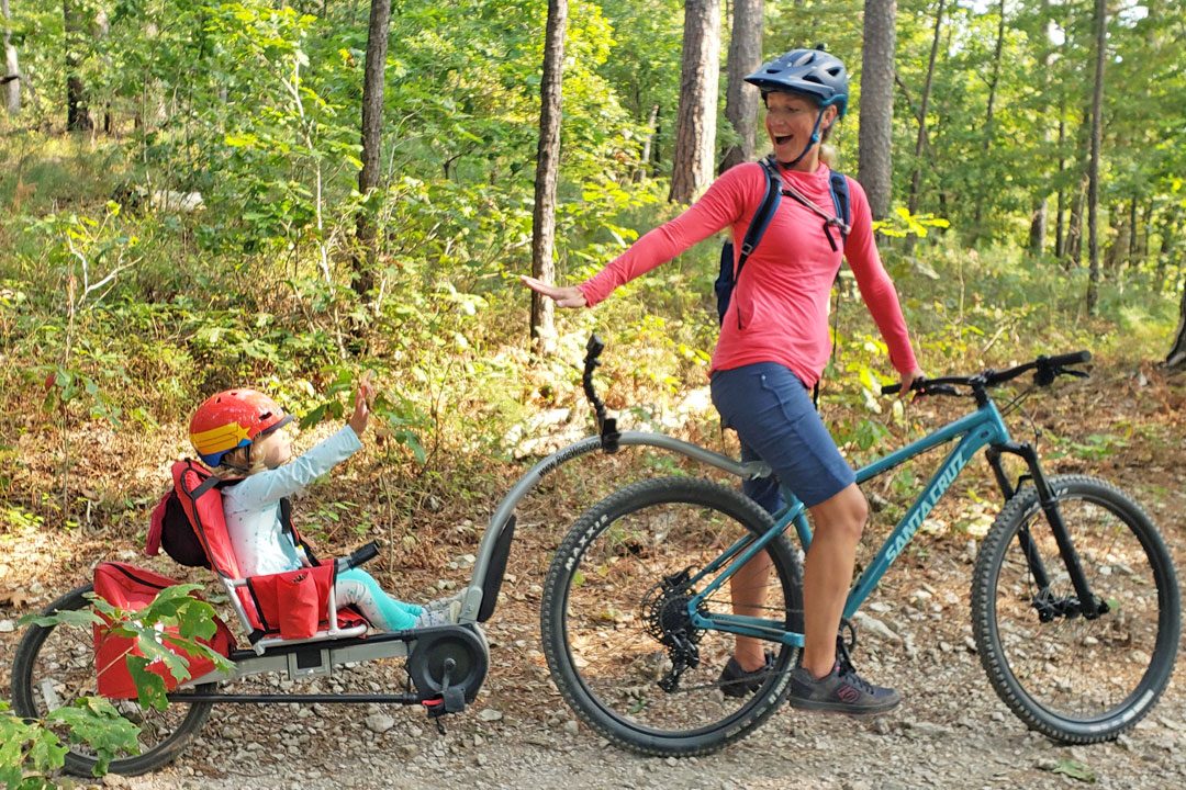 Mom pulling 3-year-old on a trail in the Weehoo Turbo recumbent trailer cycle