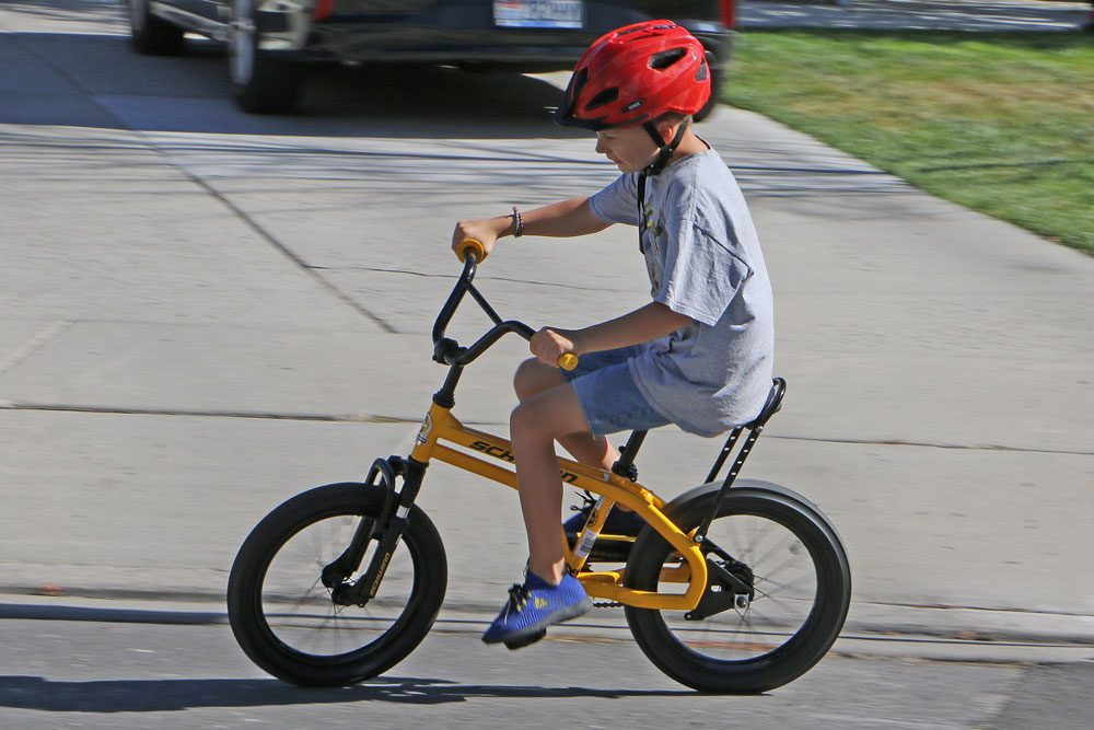 9 year old riding Schwinn Krate EVO kids bike down the sidewalk. With his bum scooted back on the seat, he has plenty of room to ride.