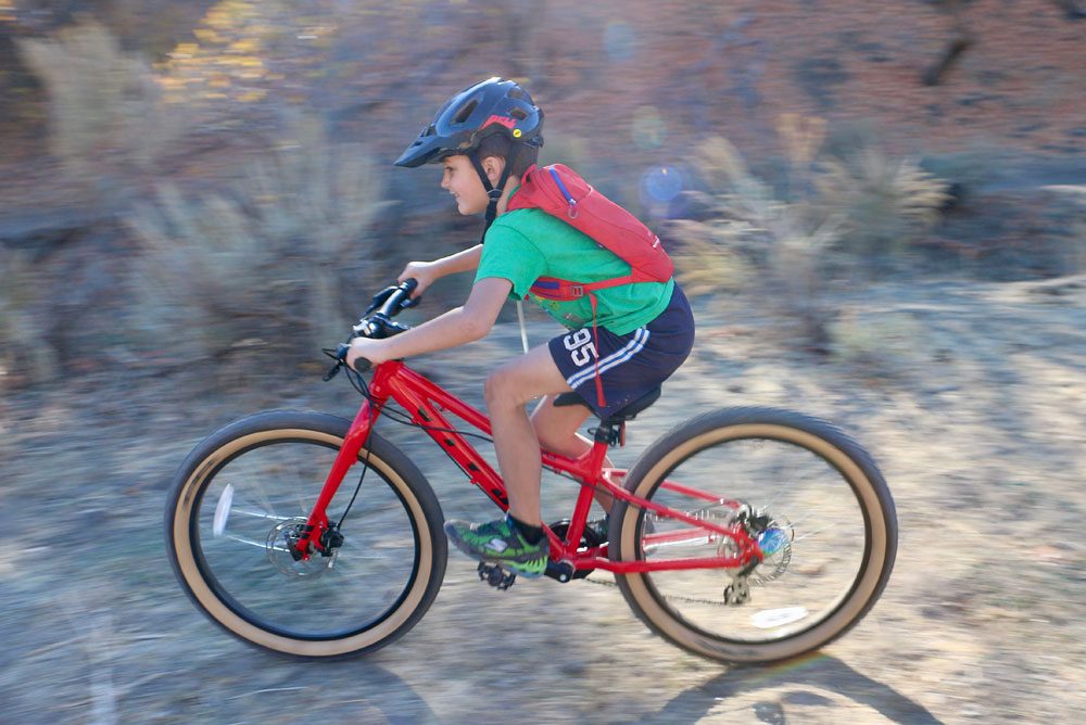 8 year old riding Vitus Plus 24 inch kids bike, speeding down trail