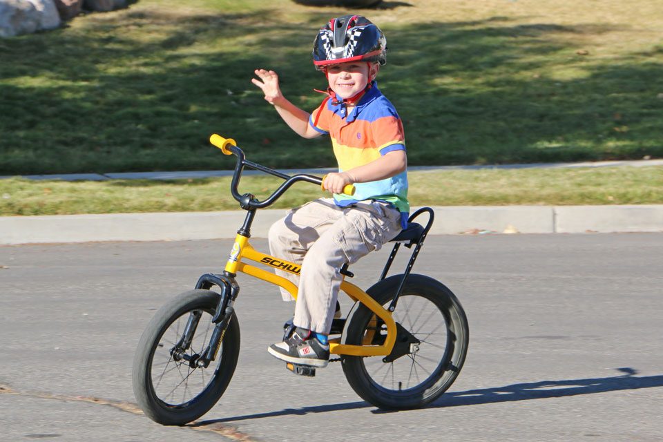 5 year old smiling and riding the Schwinn Krate EVO kids bike down the street