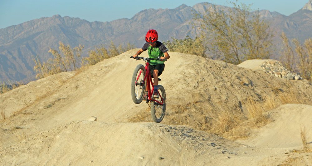9 year old catching air on dirt jump while riding Vitus