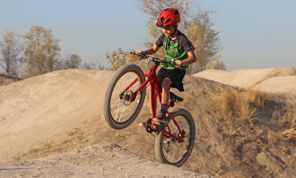 9 year old riding Vitus kids bike up dirt jump