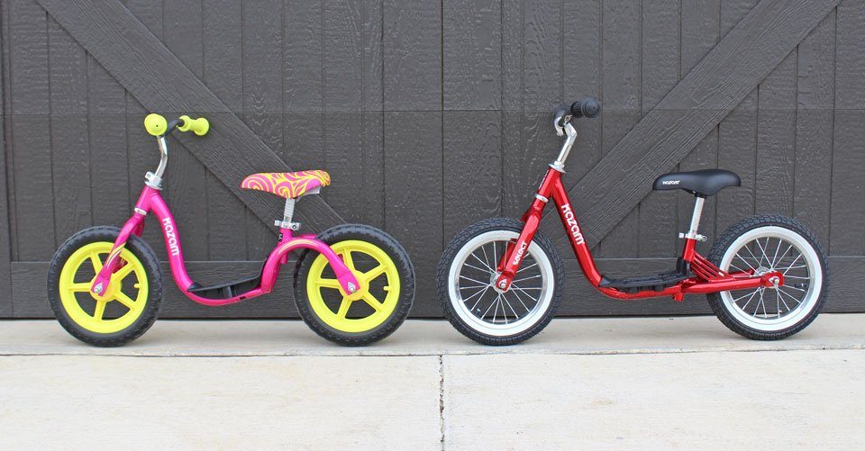 Two Kazam balance bikes next to each other. One has foam tires, the other has air tires