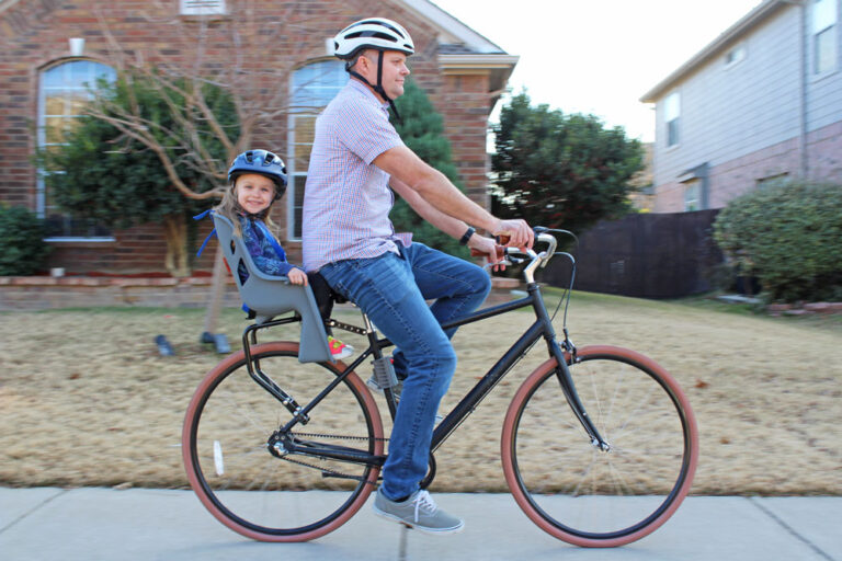 Dad riding with toddler sitting in the Bell Cocoon 300