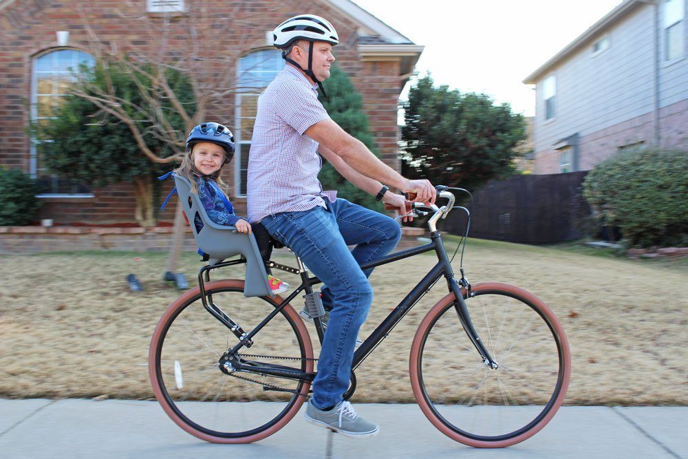 Dad riding with toddler sitting in the Bell Cocoon 300