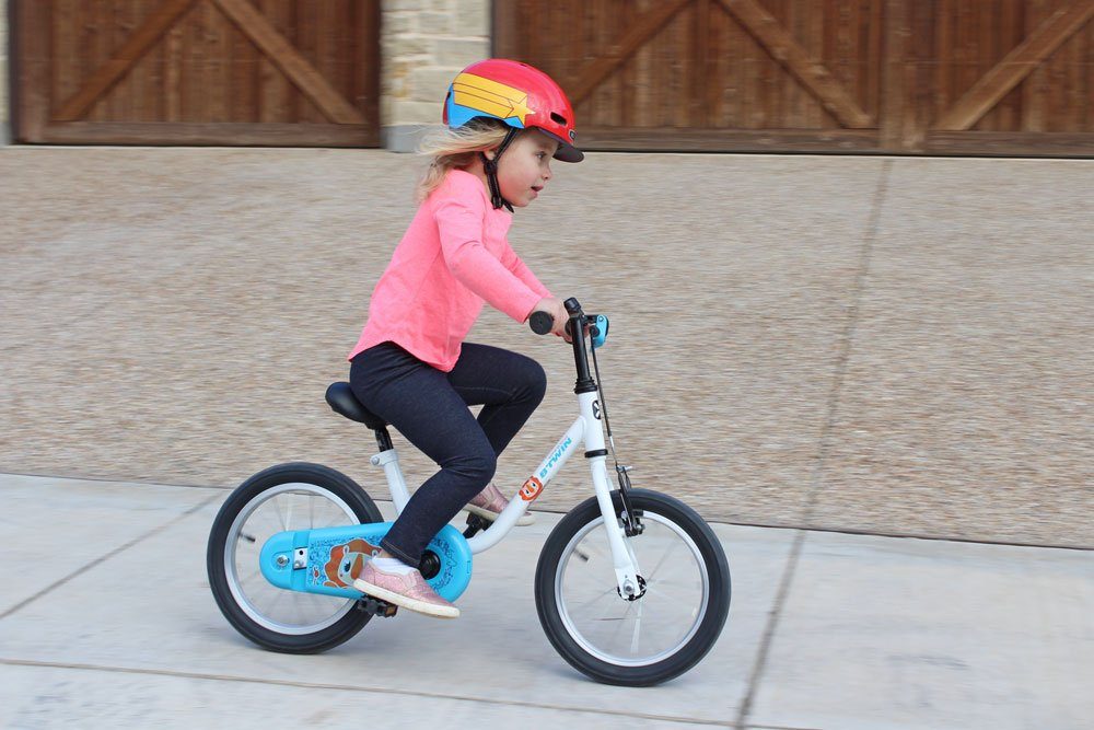 3 year old riding Btwin 14 inch kids bike down the sidewalk