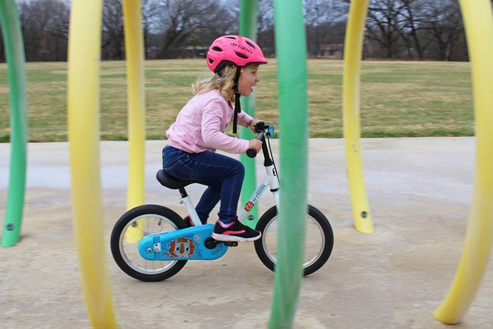 Young girl riding the Btwin 14 on a splash pad
