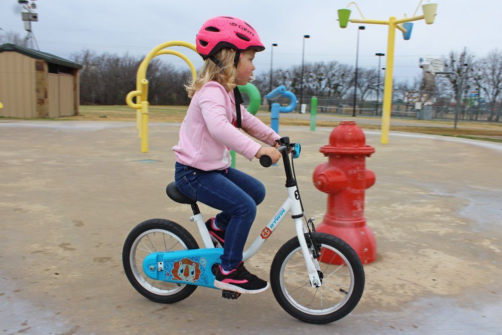 Child riding Btwin 14 inch kids bike around a playground