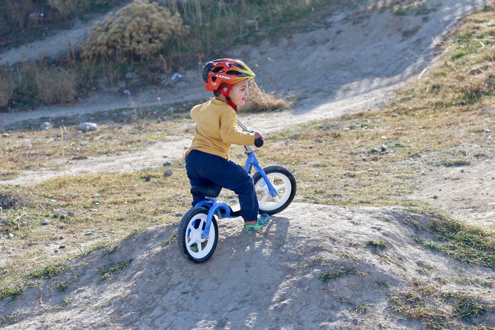 toddler riding Kazam balance bike up a hill