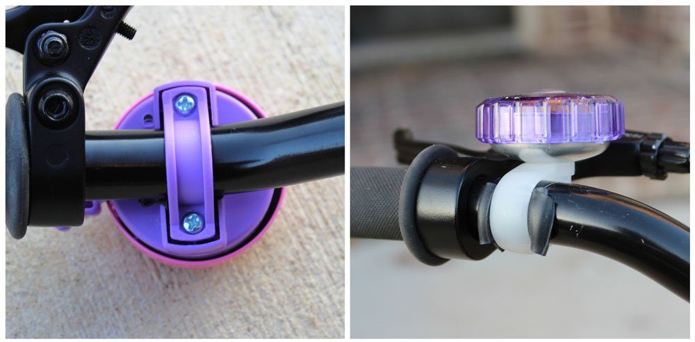 underside of two kids bike bells, showing how they attach to the handlebars. One has a piece of rubber under the clamp because the handlebar is too narrow