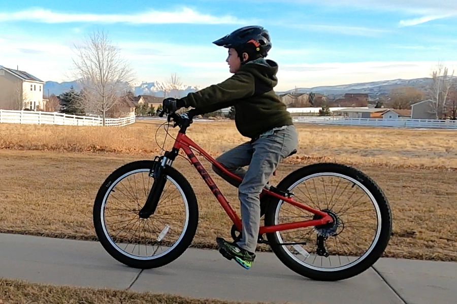Boy riding the Precaliber 24 on a sidewalk.