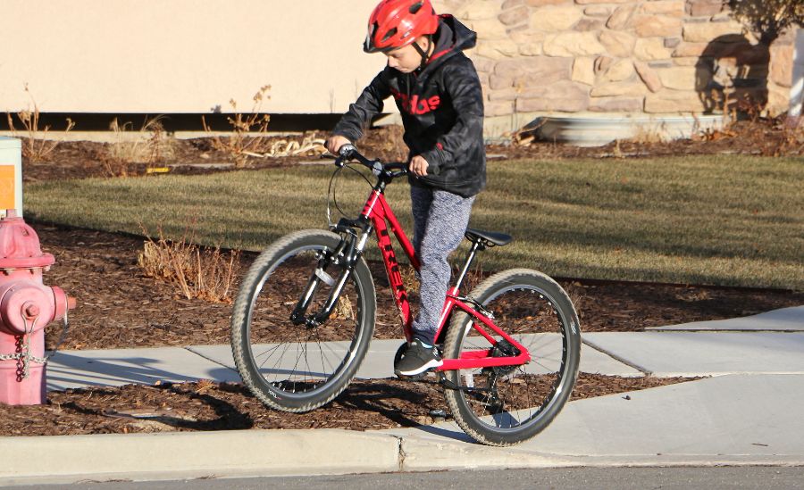 boy jumping the curb on the Trek Precaliber with suspension