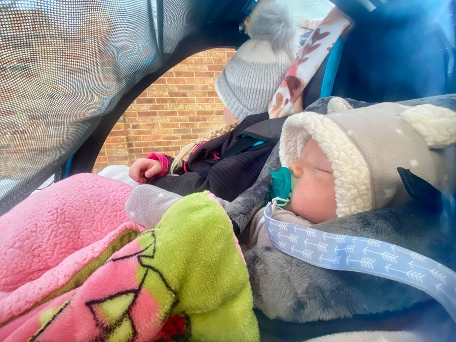 Baby sleeping in the Burley Baby Snuggler, side view through the window.