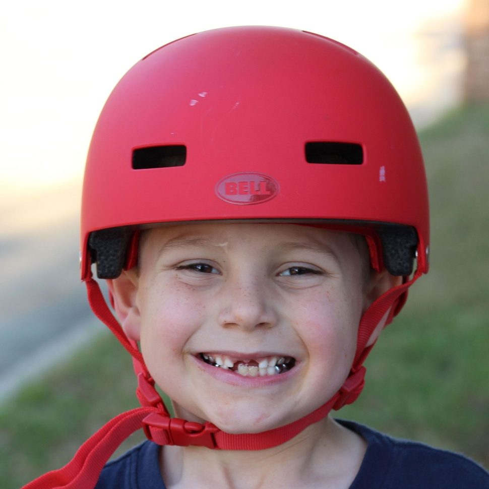 young boy wearing a red bell span helmet 