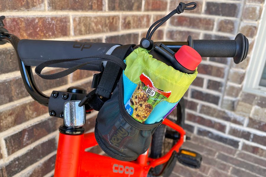 Kids bike water bottle holder by PoCampo. Hanging off handlebars of child's bike.