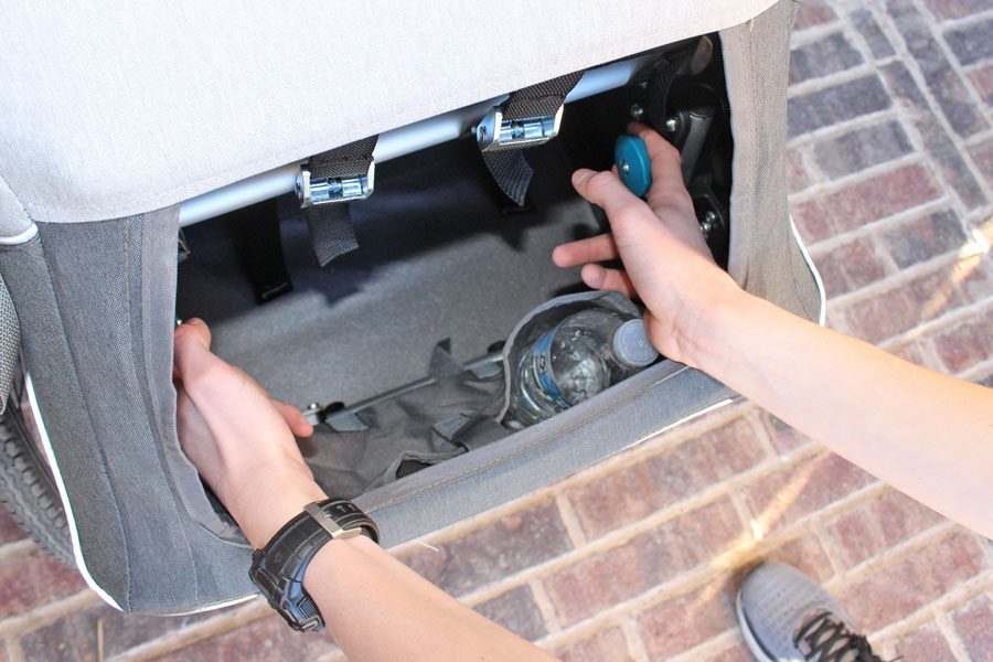 Pulling blue knobs in rear of Kidgoo to begin process of folding the trailer