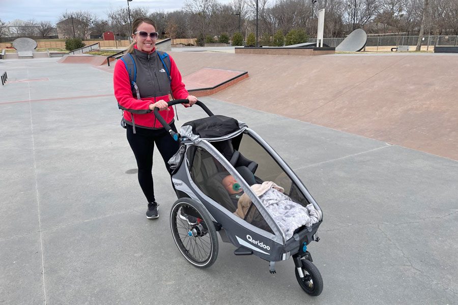 Mom smiling with Kidgoo jogger at the skatepark