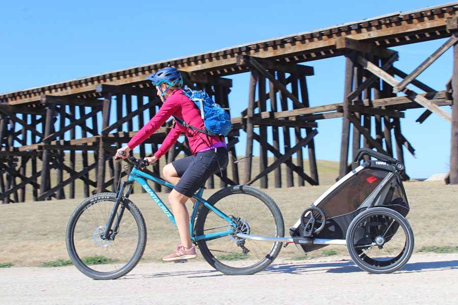 Mom pulling Thule Chariot Lite on gravel road