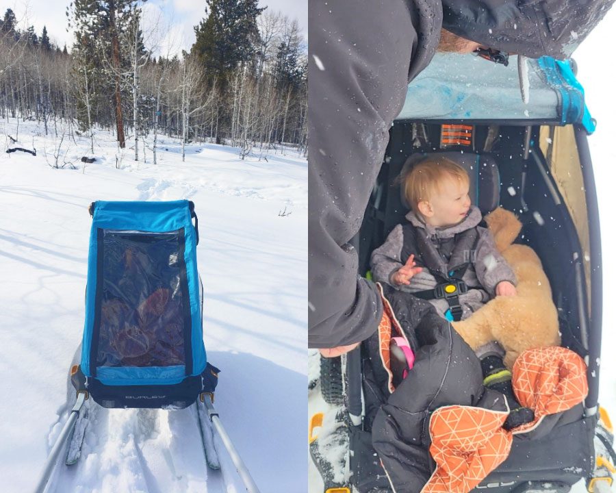 Toddler sitting in the Burley trailer with rain cover pulled over so he's snug and warm