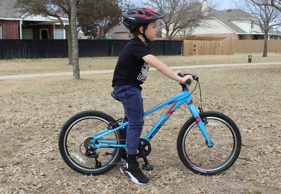 Side shot of 7 year old on Polygon 20 inch kids bike, showing his body position
