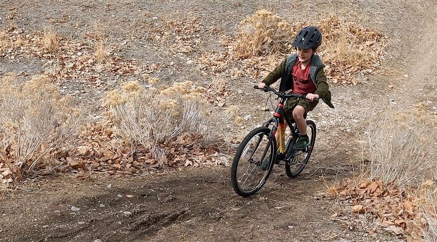 boy testing out the 24 inch polygon Premier Ultralight on a dirt trail