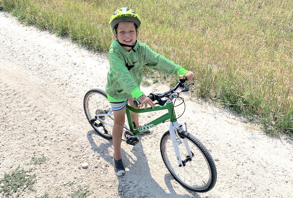 young rider on a woom 4 on a gravel path