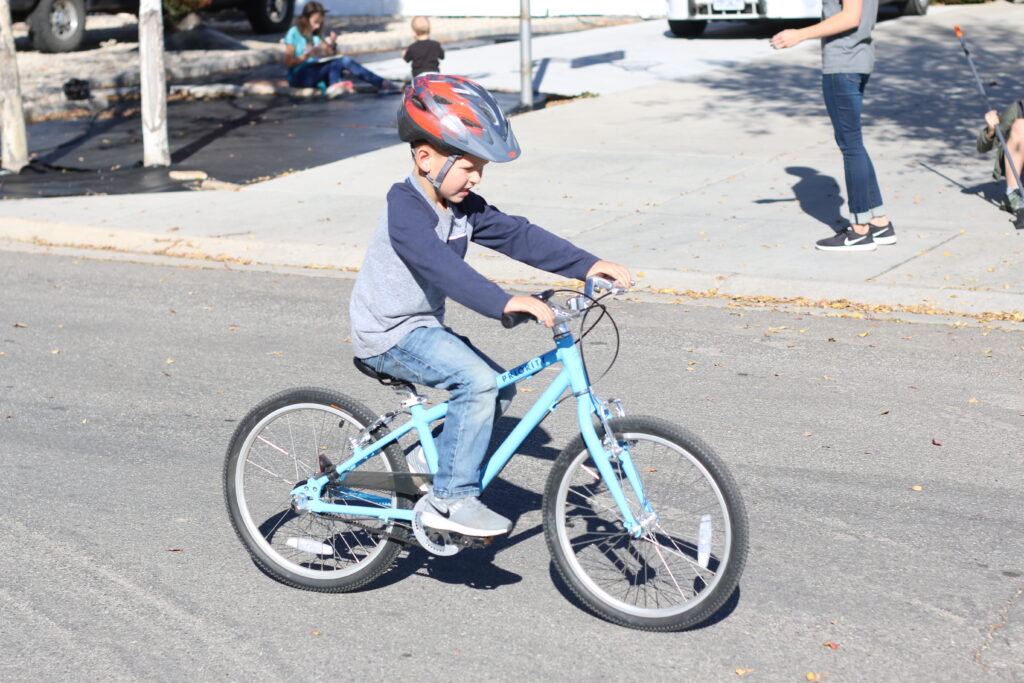 Young boy riding the Priority Start 20 kids bike around the neighborhood
