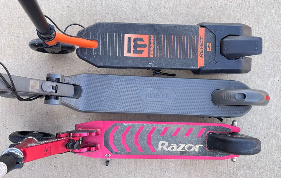 Three kids electric scooters stacked next to each other, showing differences in deck size