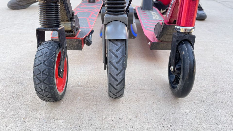 Three different kids electric scooters showing different wheel types upclose