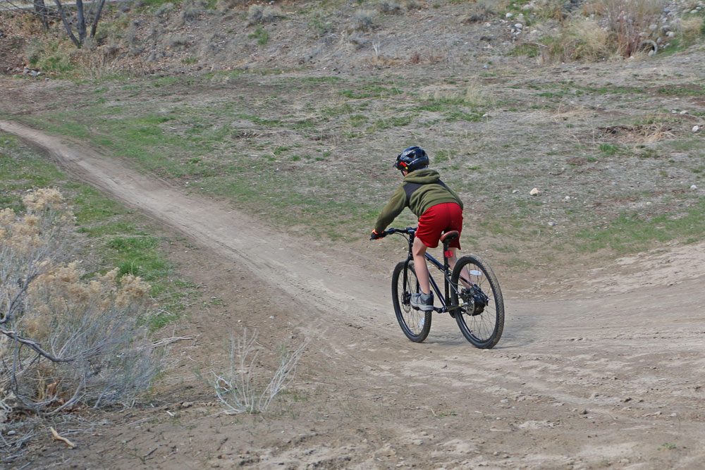 boy riding a Cleary Meerkat 24 down a dirt hill