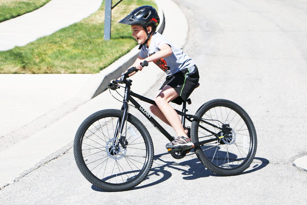 boy riding a black cleary meerkat 24 in his neighborhood