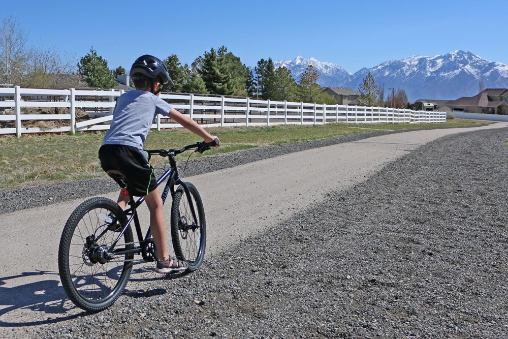 boy riding the Cleary Meerkat 24 kids bikes along a paved bike trail